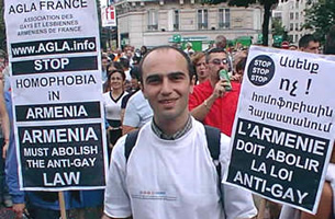 A member of the Armenian Gay and Lesbian Association France holds gay pride posters. 2002. Wikimedia Commons